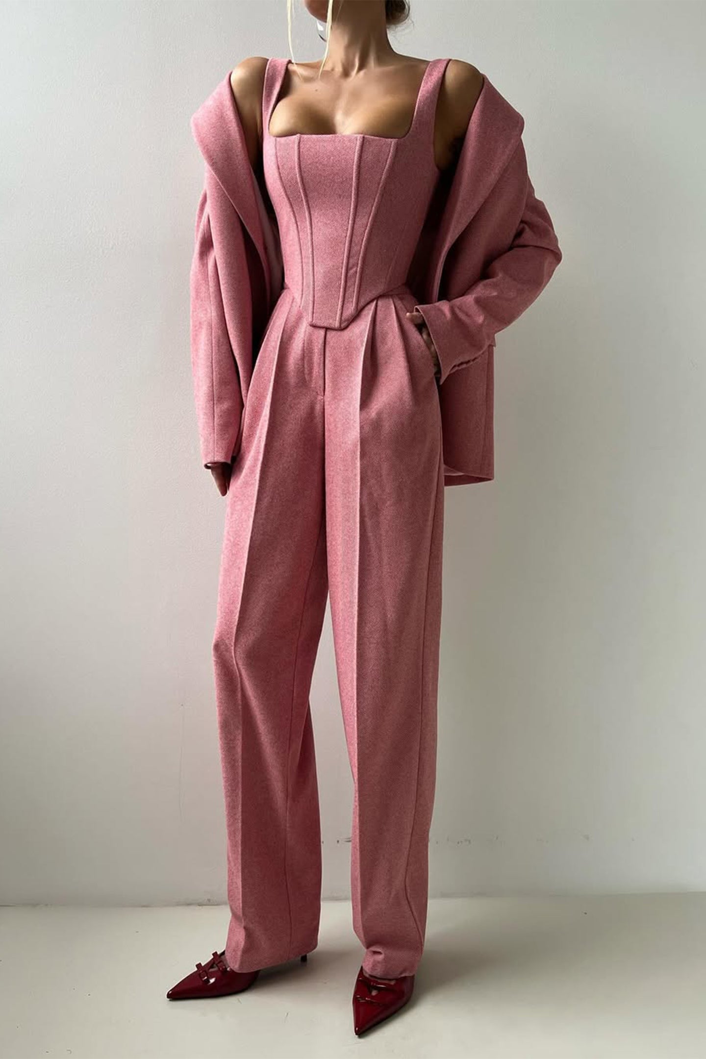"Elegant women's three-piece suit with structured blazer, bustier top, and wide-leg trousers in classic herringbone weave."