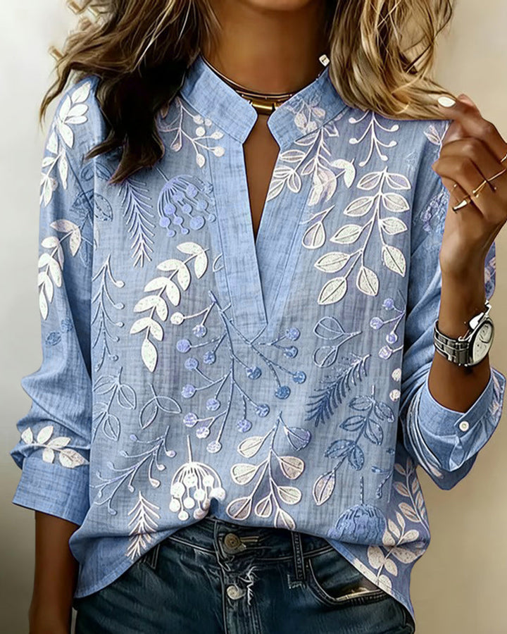 Close-up of the pastel floral print and V-neck detail on a women's blouse.