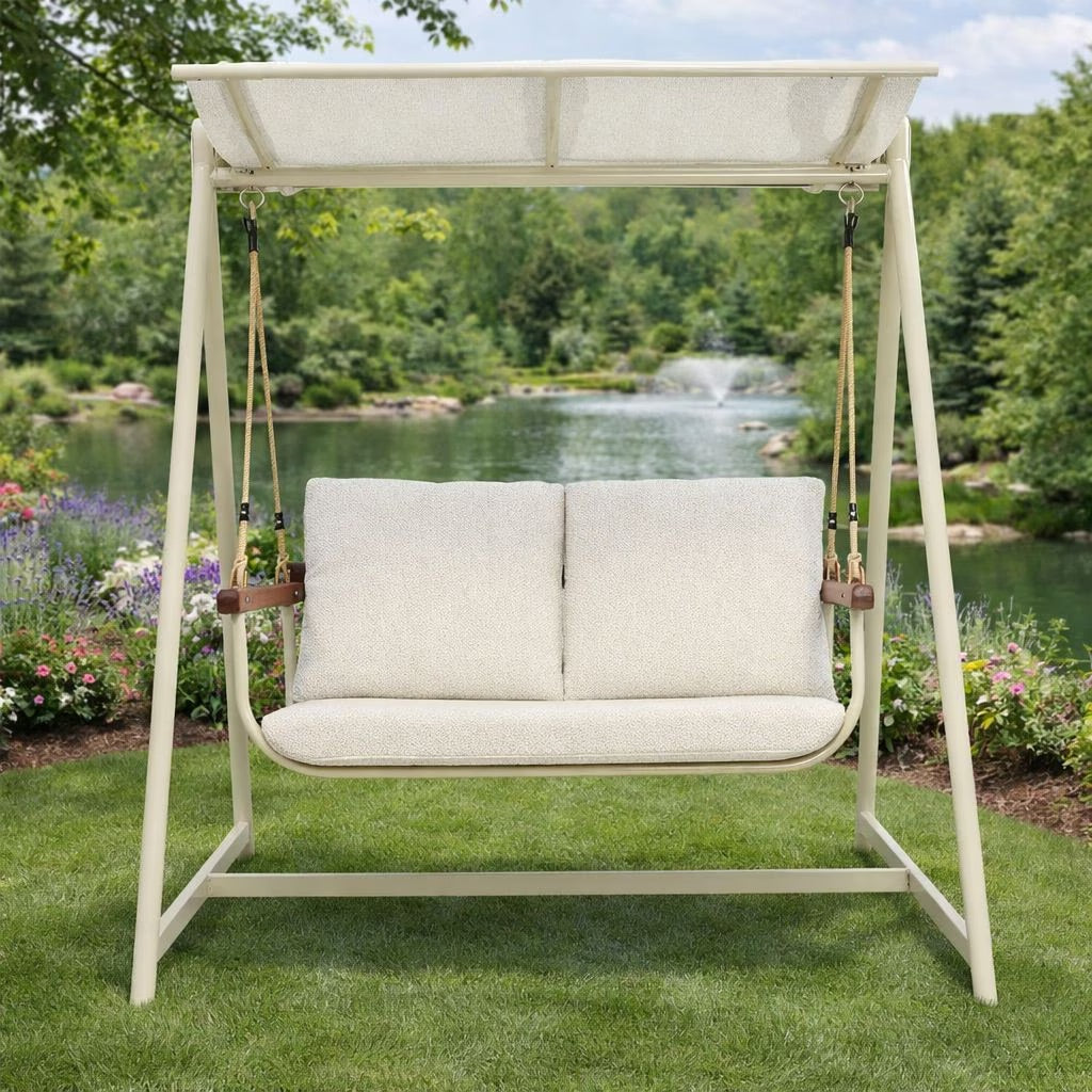 Cream 2-seater outdoor patio swing with plush cushions & durable aluminum frame for garden relaxation.