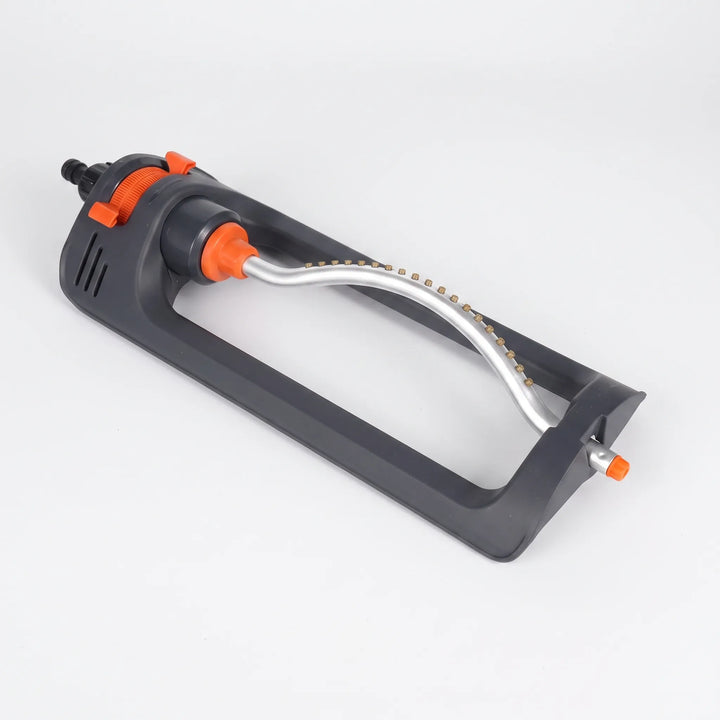 Oscillating lawn sprinkler actively watering a lush green lawn, providing effortless yard irrigation.