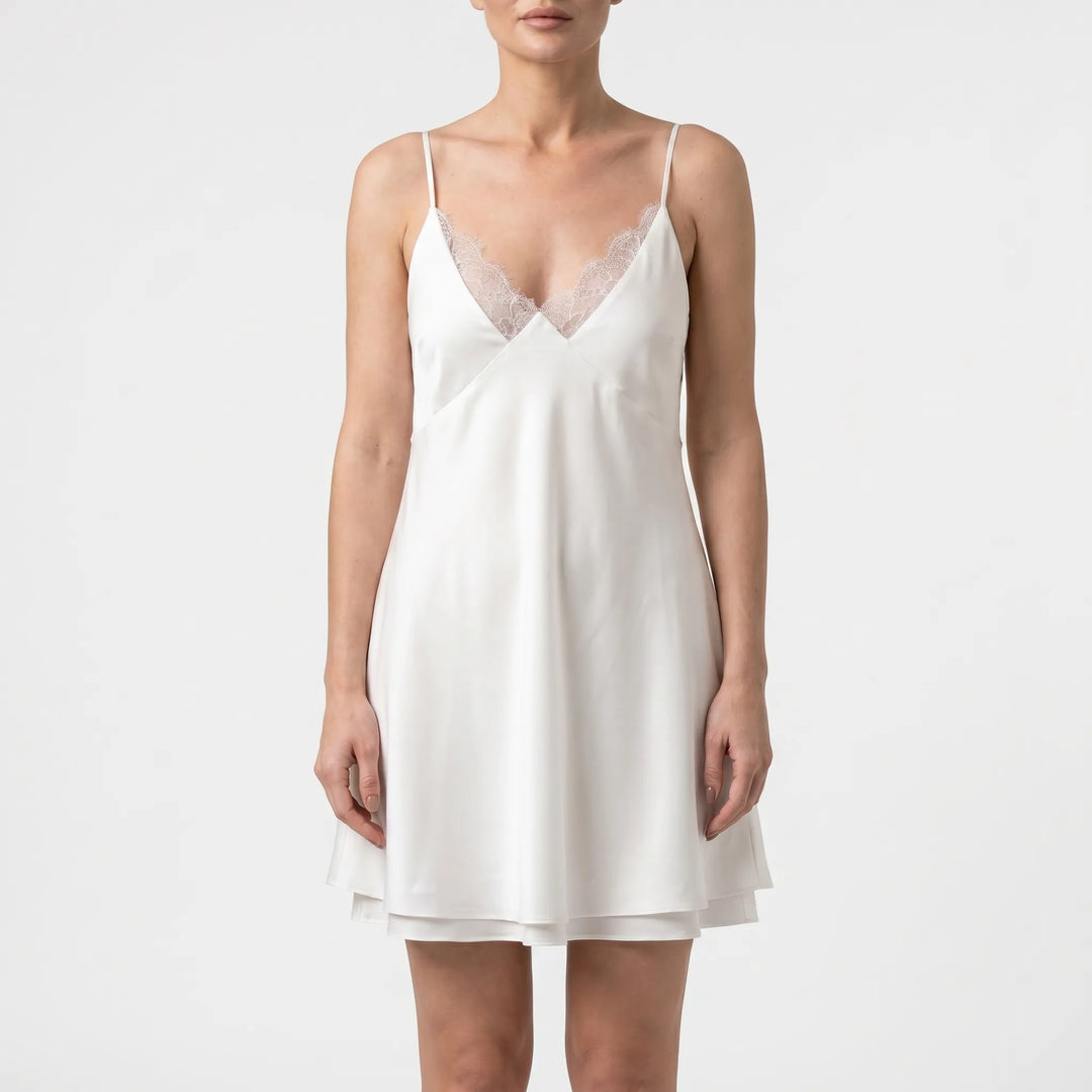 Stylish A-line white mini dress for women, featuring a chic backless design and thin spaghetti straps for parties.