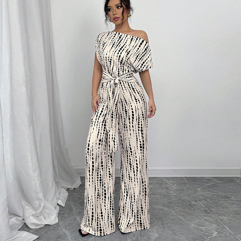 Elegant white printed wide leg women's jumpsuit with a chic one-shoulder design and a stylish belt. Perfect for parties.