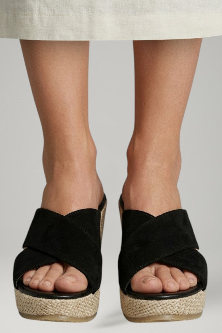 Stylish black slip-on wedge sandals for women, offering elevated comfort and easy wear.