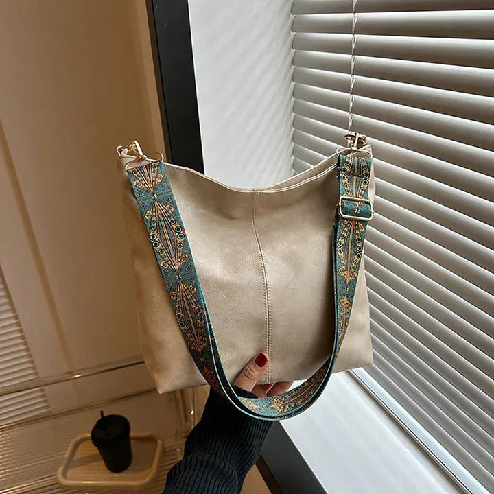 Close-up of the unique patterned strap on a women's bohemian faux leather shoulder bag, hobo style.