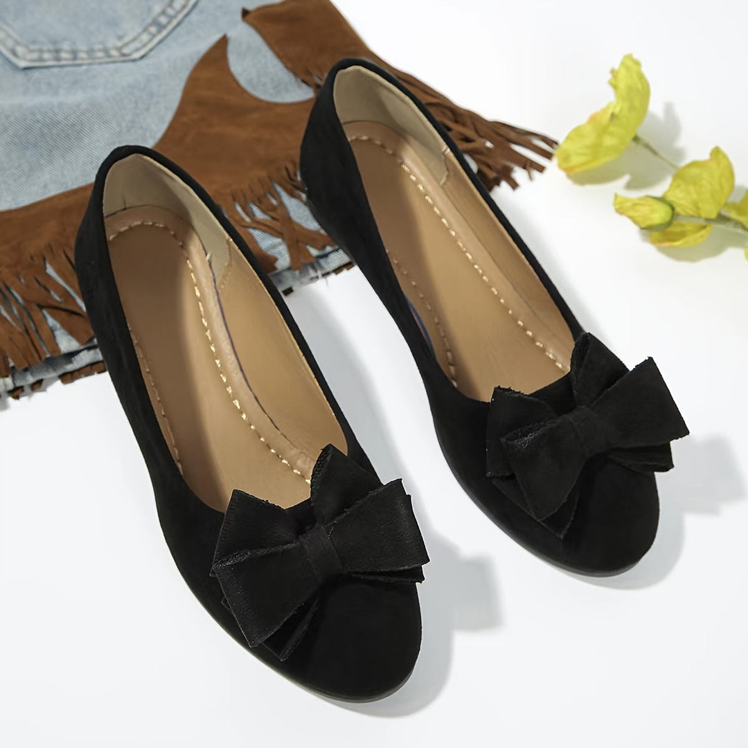 Women's elegant slip-on wedge shoes with a chic bow detail, perfect for stylish comfort.