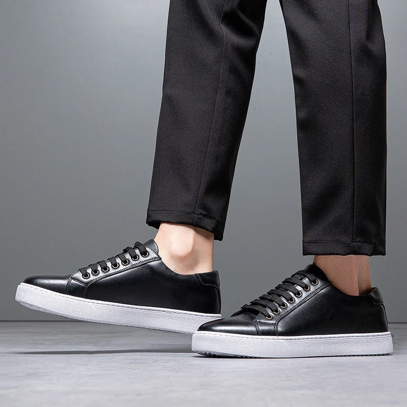 Men's leather low-top sneakers paired with jeans, showcasing a smart casual look.
