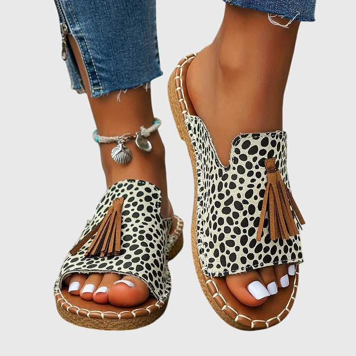 Elegant open-toe slip-on sandals for women, with playful tassels, ideal for comfortable beach days.
