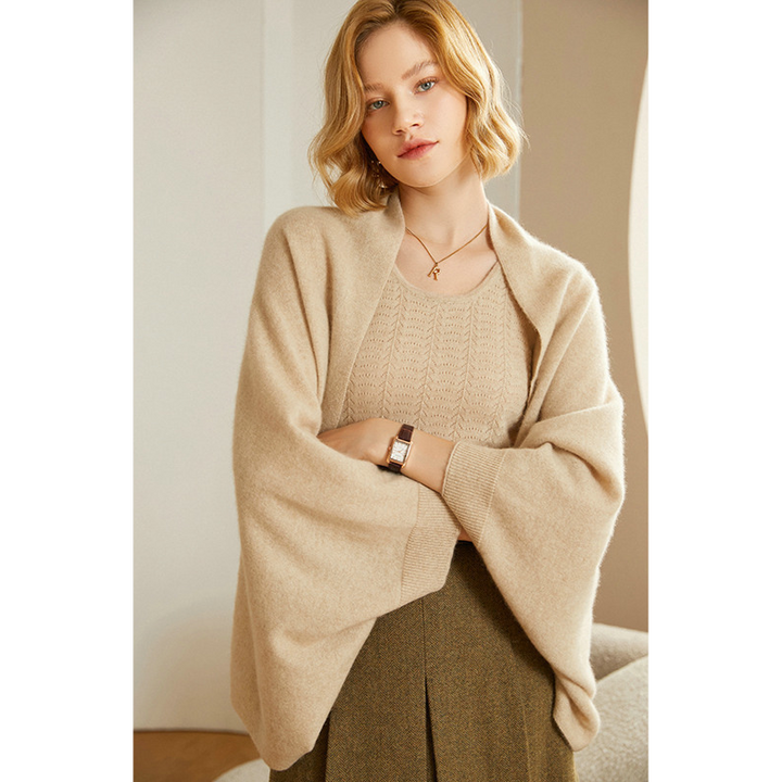 Folded beige knit shawl wrap, showing its compact and travel-friendly design.