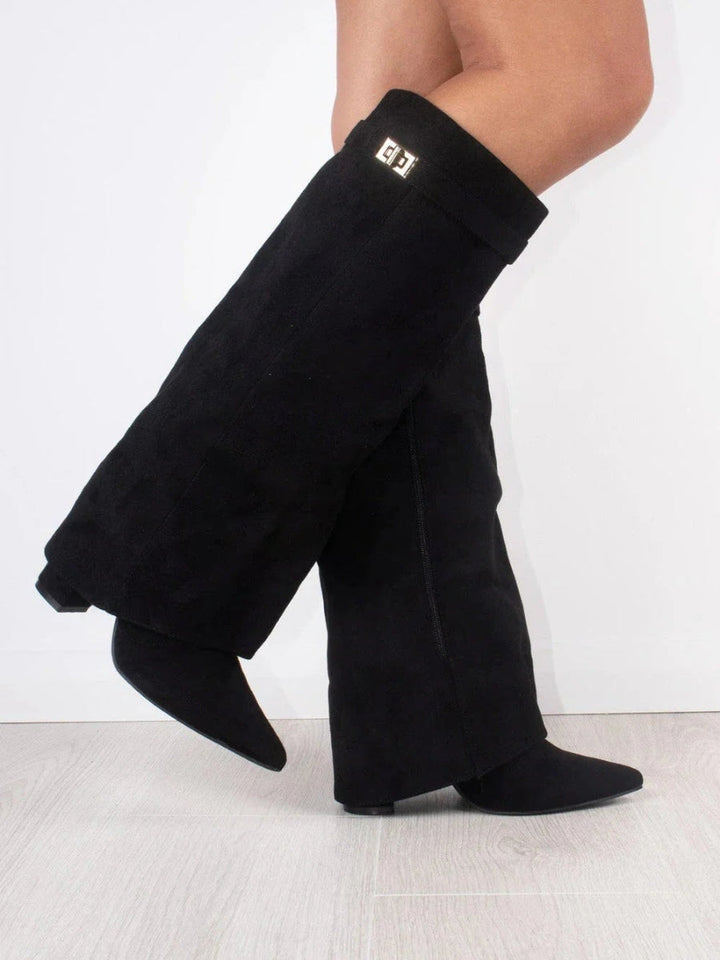 Close-up of the buckle detail on luxurious black leather thigh-high boots for women.