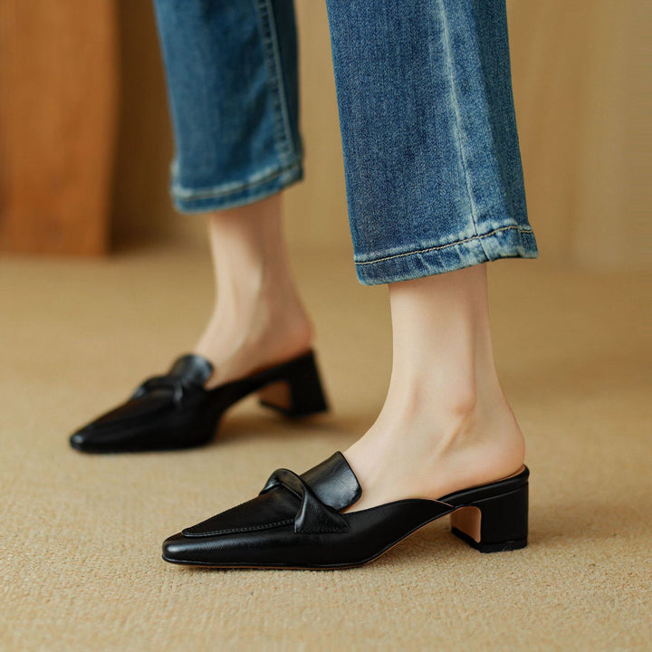 Fashionable black leather bow mules for women, providing both comfort and elegance