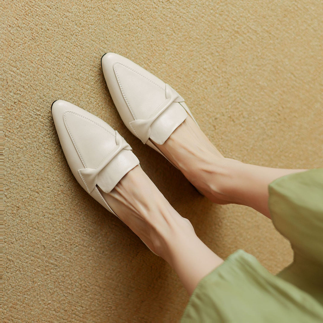 Side view of women's comfortable brown leather bow mules, showcasing elegant design