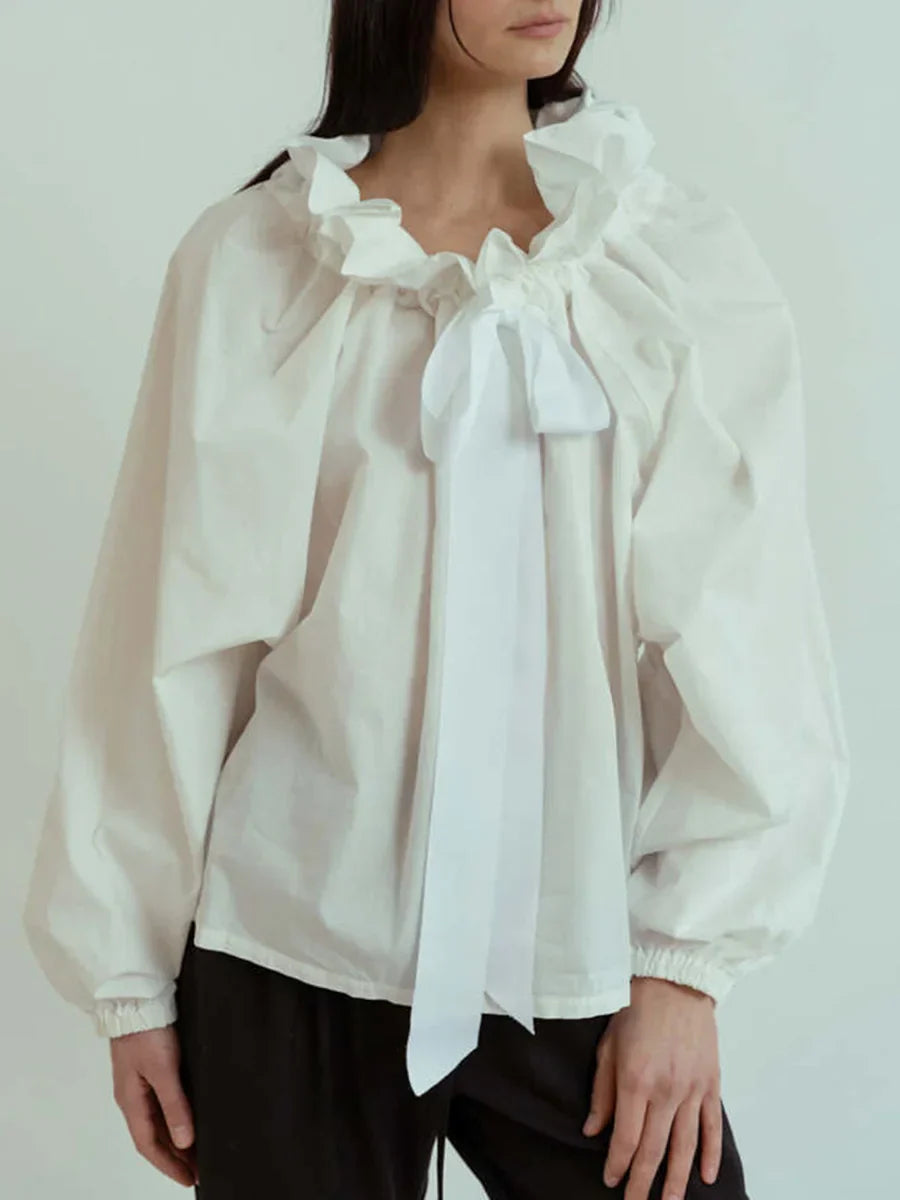 Side profile of a women's elegant white blouse, emphasizing the unique puffed lantern sleeves.