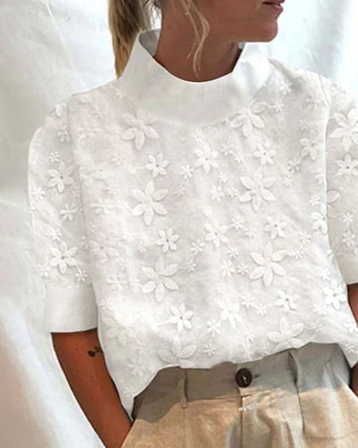 Elegant white women's blouse with sophisticated stand collar and delicate floral embroidery, perfect for formal or casual wear.