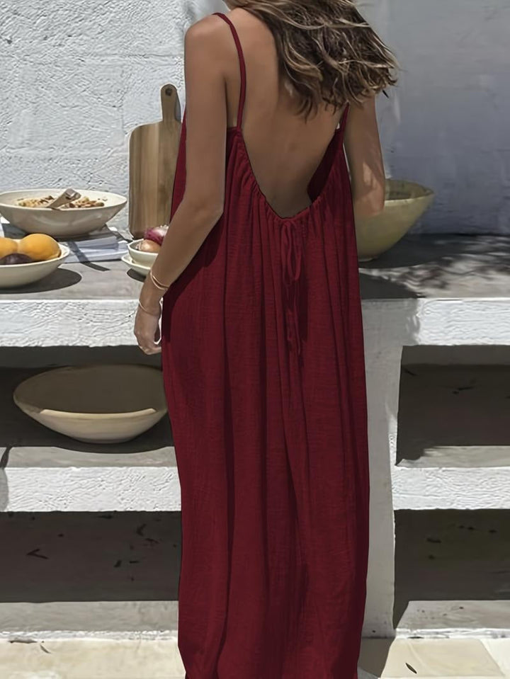 Side view of a woman wearing a backless cotton-linen maxi dress, showcasing the silhouette.