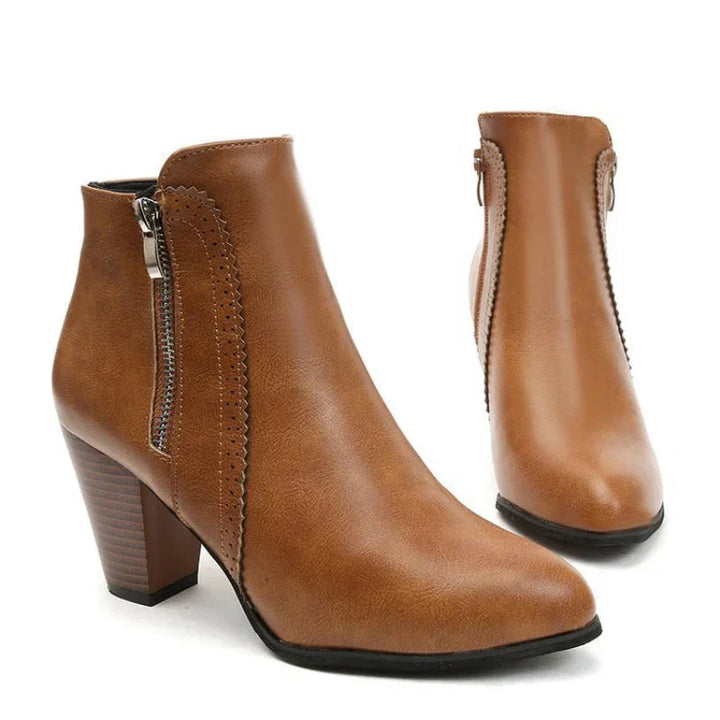 Close-up of women's leather ankle boots with unique scalloped edge design and sturdy block heel, ideal for footwear.