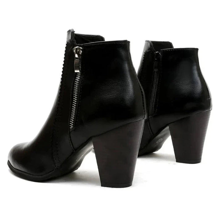 Black leather women's ankle boots with a chic scalloped trim and stable block heel, a versatile footwear option.