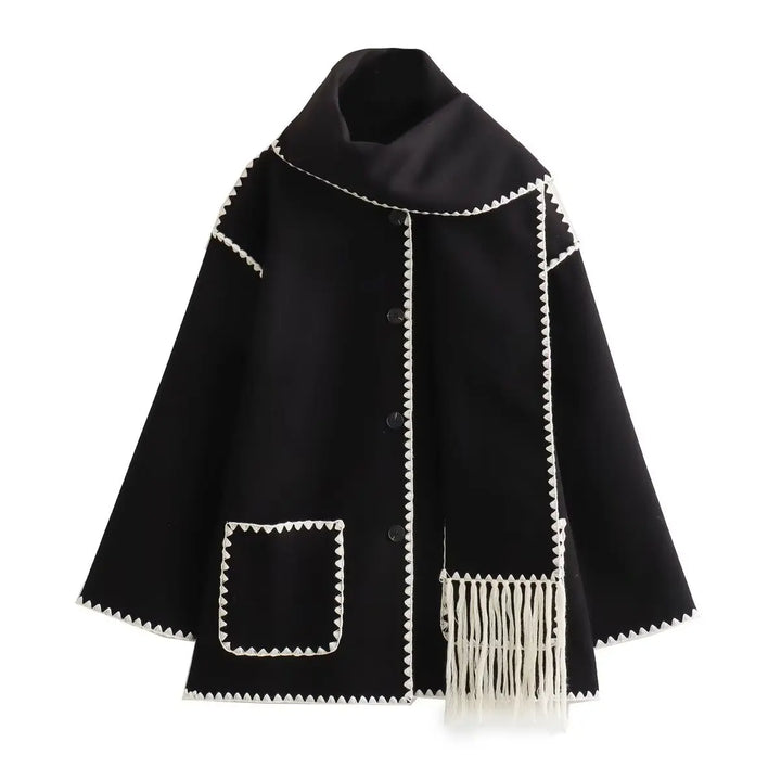 Close-up of the elegant fringe detail on a women's black wool blend wrap coat, trendy outerwear
