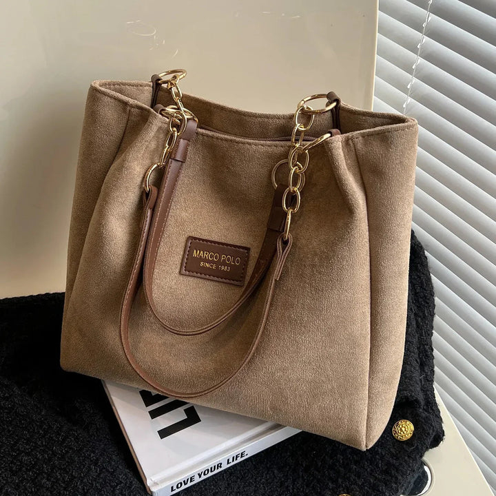 Close-up of a women's elegant brown suede tote bag, showcasing the soft texture, ideal as a daily carryall.