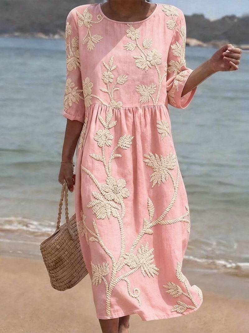 Detailed view of vibrant floral embroidery on a comfortable women's midi dress with three-quarter sleeves.