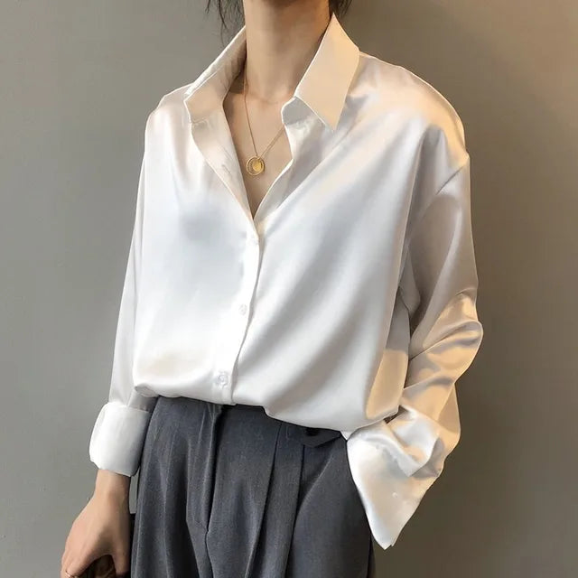 Fashionable women's satin shirt with button-down front and long sleeves, showcasing the fabric's lustrous drape.