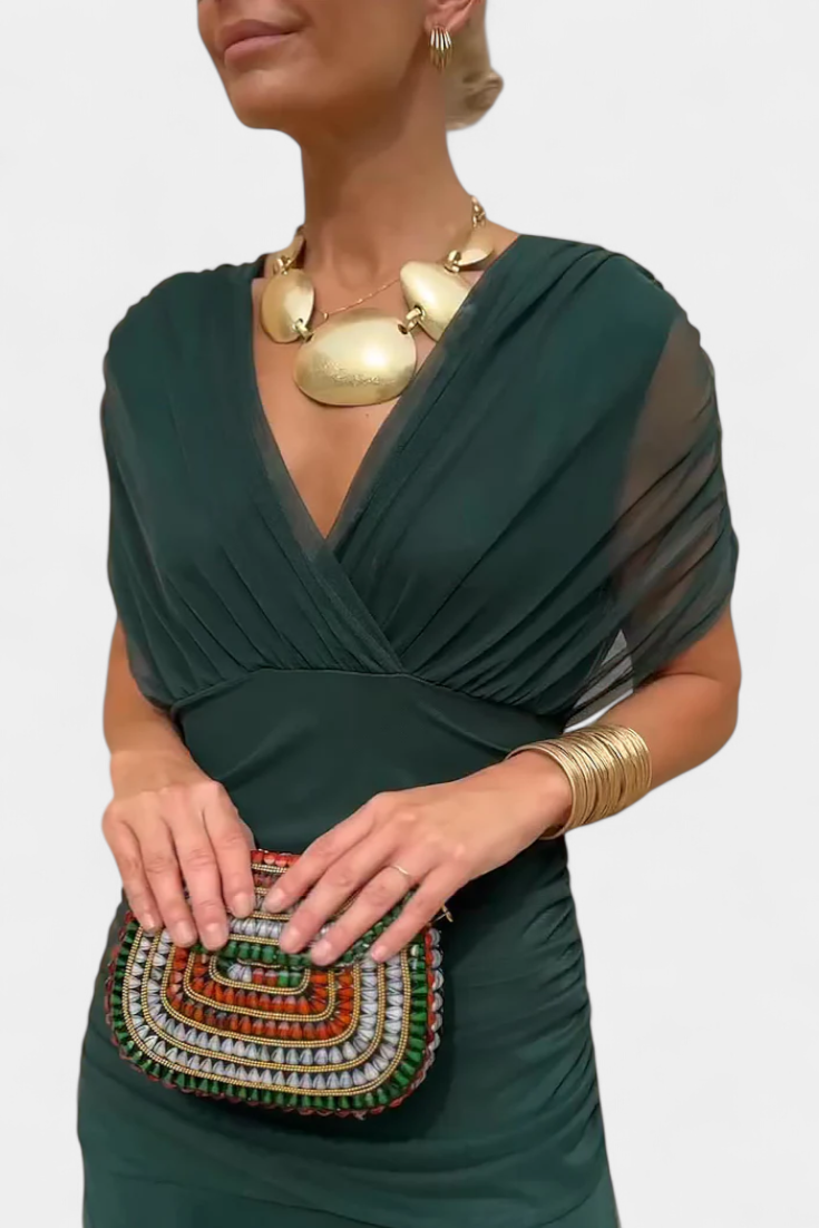 Close-up of the elegant off-shoulder neckline & ruched detail on a women's twist front midi dress.