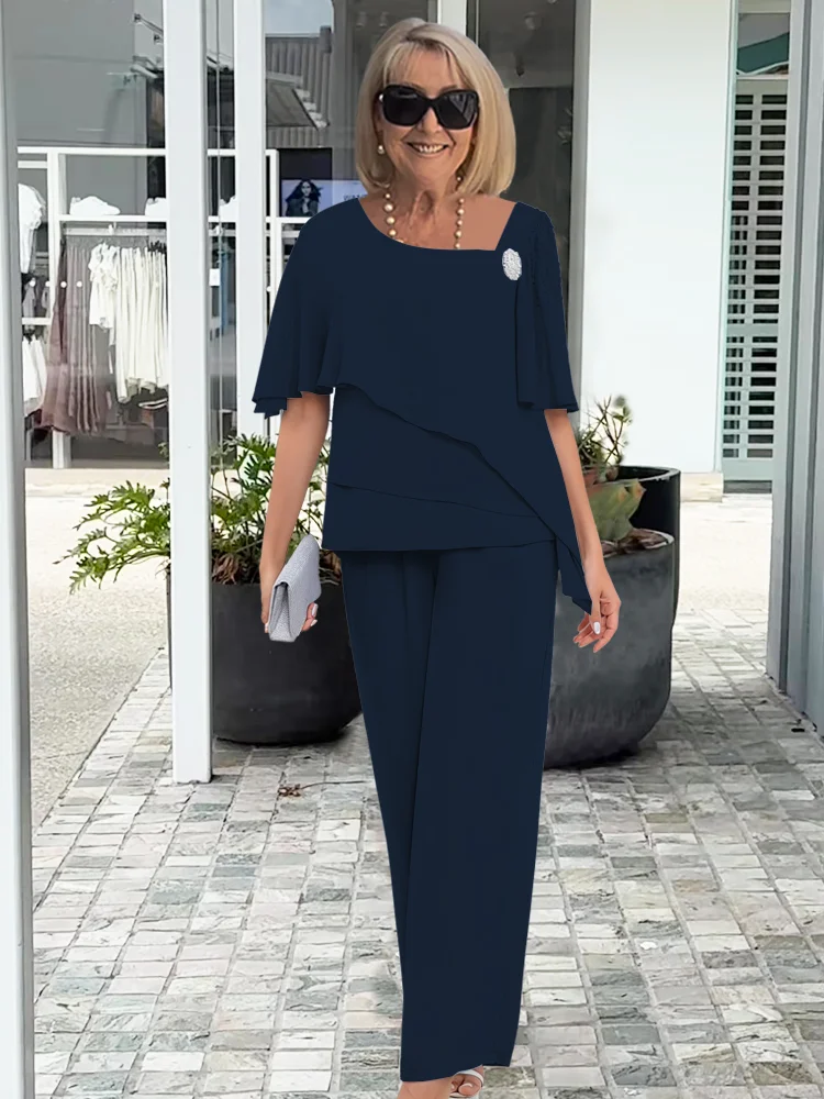 Navy blue women's sophisticated two-piece outfit with a unique cape top & sleek trousers, perfect for parties.