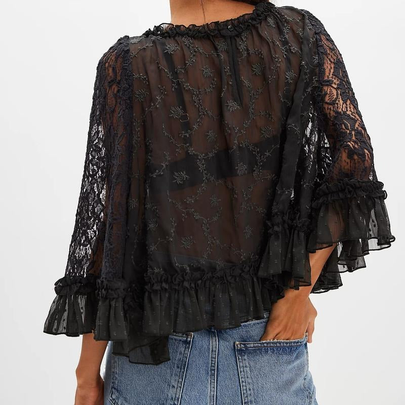 Close-up of a sophisticated women's lace ruffle blouse, featuring intricate floral patterns and sheer fabric