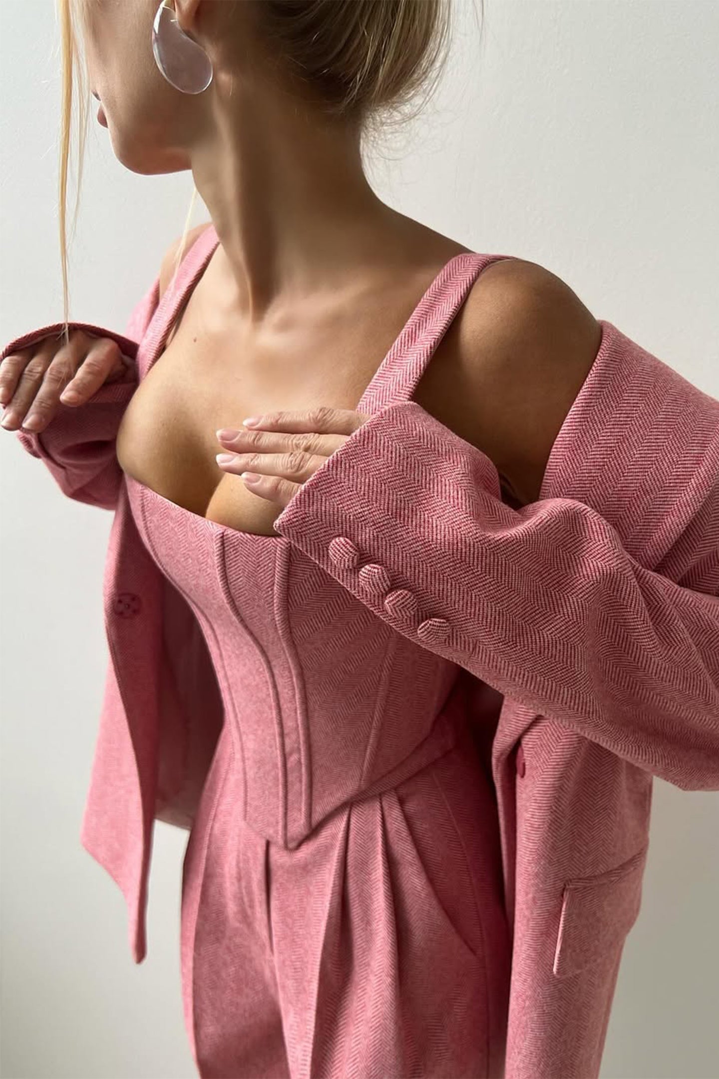 "Elegant women's three-piece suit with structured blazer, bustier top, and wide-leg trousers in classic herringbone weave."