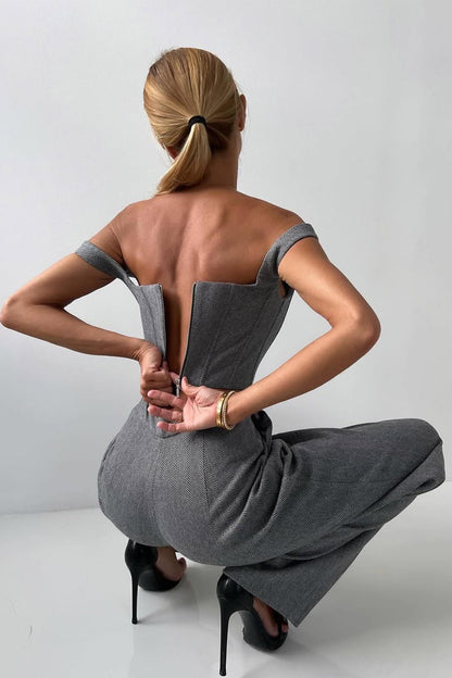 "Elegant women's three-piece suit with structured blazer, bustier top, and wide-leg trousers in classic herringbone weave."