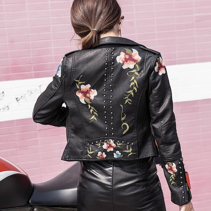 Back view of a women's chic embroidered faux leather biker jacket, showcasing its design.