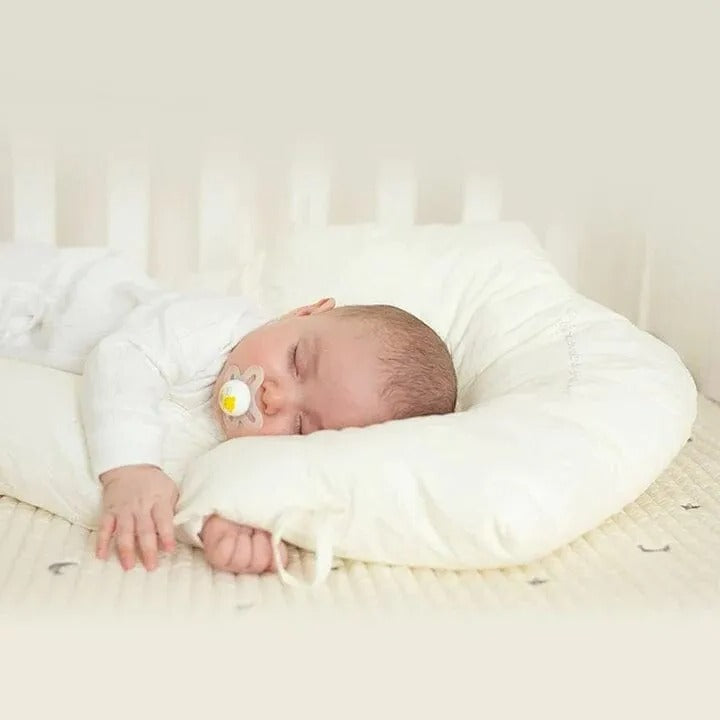 "Ergonomic infant support pillow with adjustable sides, recessed head zone for comfort and alignment, soft exterior, baby-saf