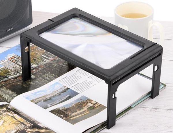 Ergonomic LED magnifier with luminous lens for elderly reading comfort, highlighting ergonomic design and compact portability