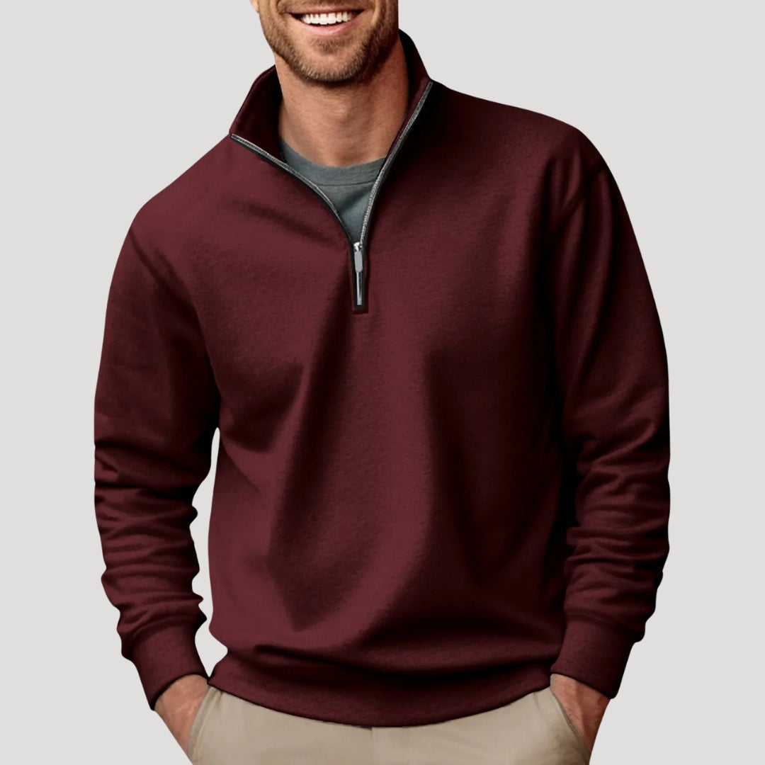 Detail of the ribbed cuffs and hem on a men's green quarter-zip pullover sweatshirt