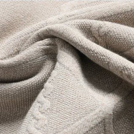 Detail of the textured cable knit pattern on a men's classic crewneck sweater, perfect for men's fashion.