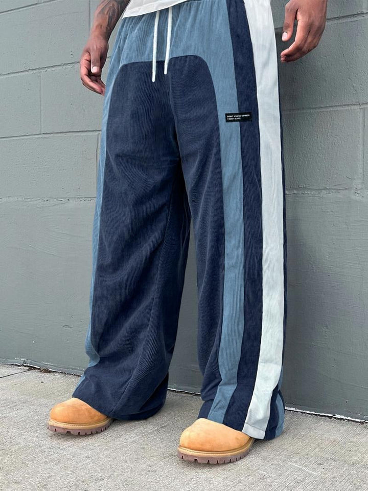 Athletic men's corduroy joggers with bold color-block panels. Comfortable and stylish for casual wear.