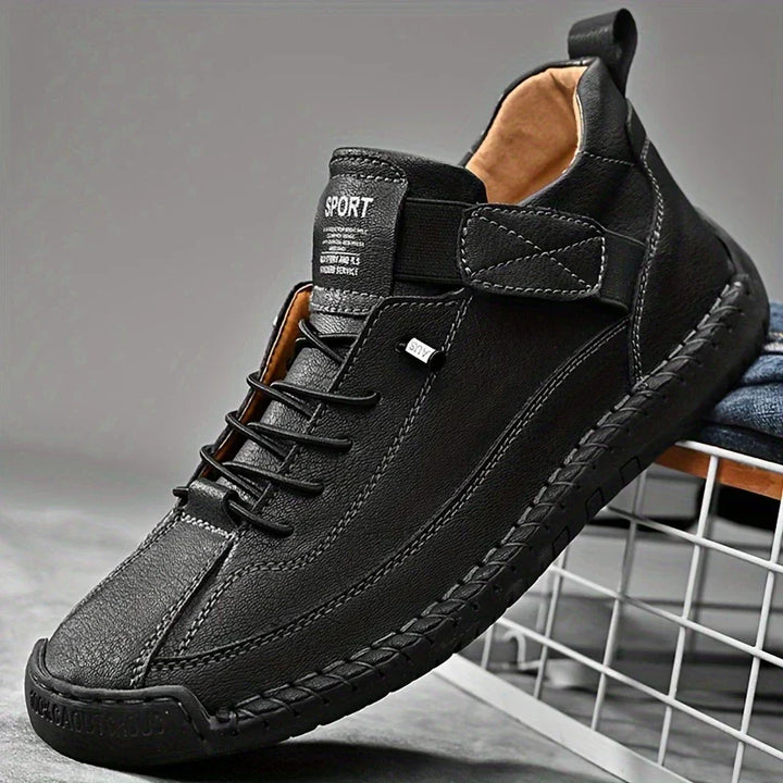Underside of men's black orthopedic leather sneakers, showing the textured sole for enhanced grip.