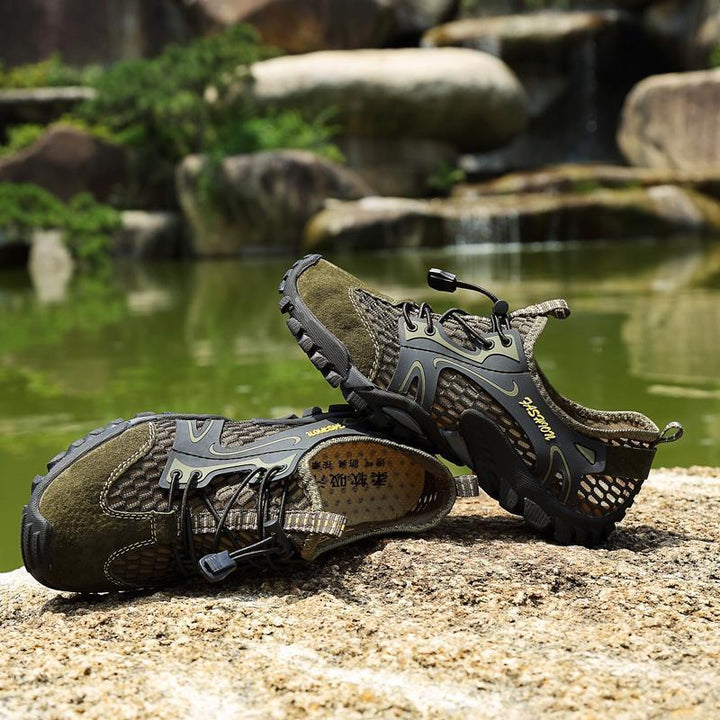 A pair of men's lightweight, all-season hiking and trail running footwear on a wooden surface