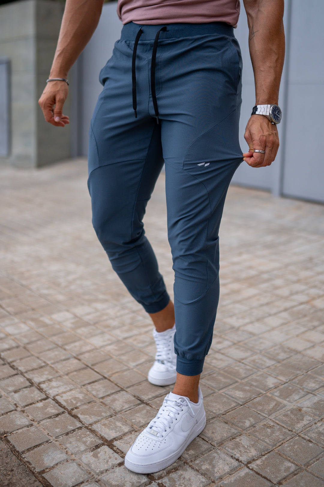Dark blue men's travel pants, performance joggers with convenient pockets, comfortable for long journeys.