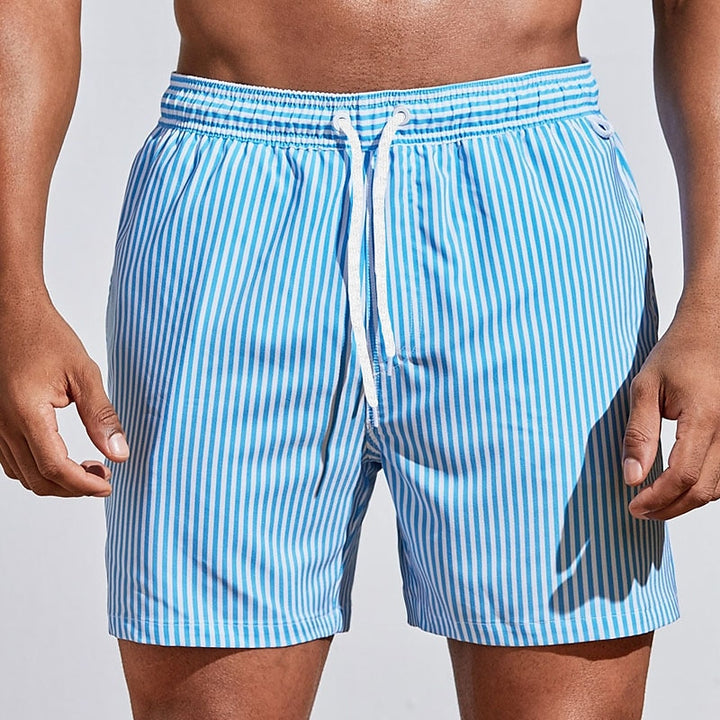 Comfortable men's striped swim trunks with adjustable drawstring waist, perfect for athletic beach wear.