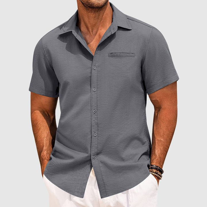 Man wearing a trendy short sleeve button-down summer shirt with a chest pocket, showcasing casual style.