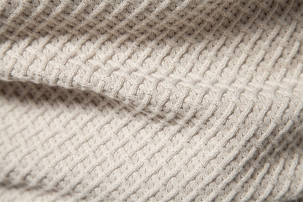 Knitted pattern focus on men's waffle knit crewneck sweater, showing craftsmanship and quality