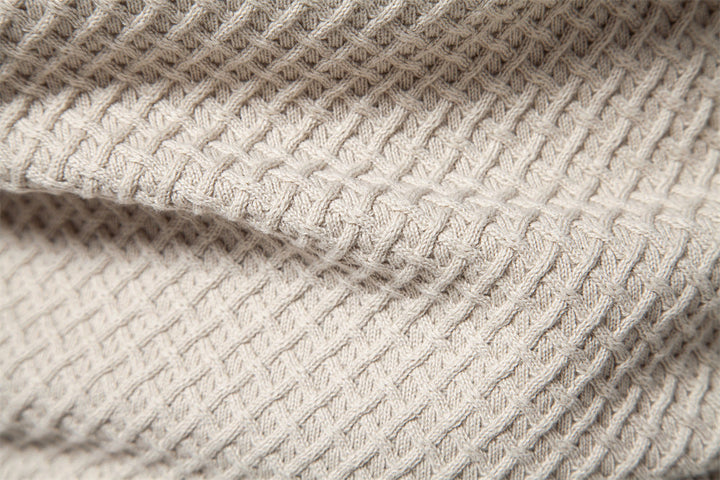 Knitted pattern focus on men's waffle knit crewneck sweater, showing craftsmanship and quality