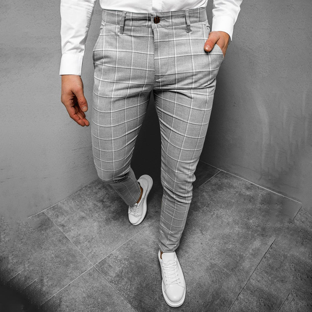 Man wearing smart tapered grid pattern trousers with a belt, emphasizing fit and comfort.
