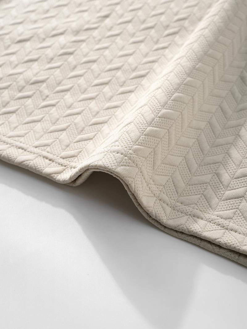 Front view of a men's textured knit short sleeve polo, featuring a subtle geometric pattern and cotton blend