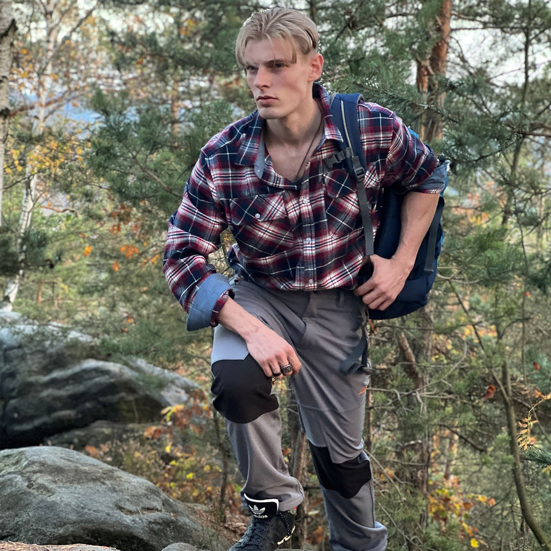 Model leaning against a wall, wearing a comfortable Men's Verona Plaid Flannel Shirt, relaxed fit.