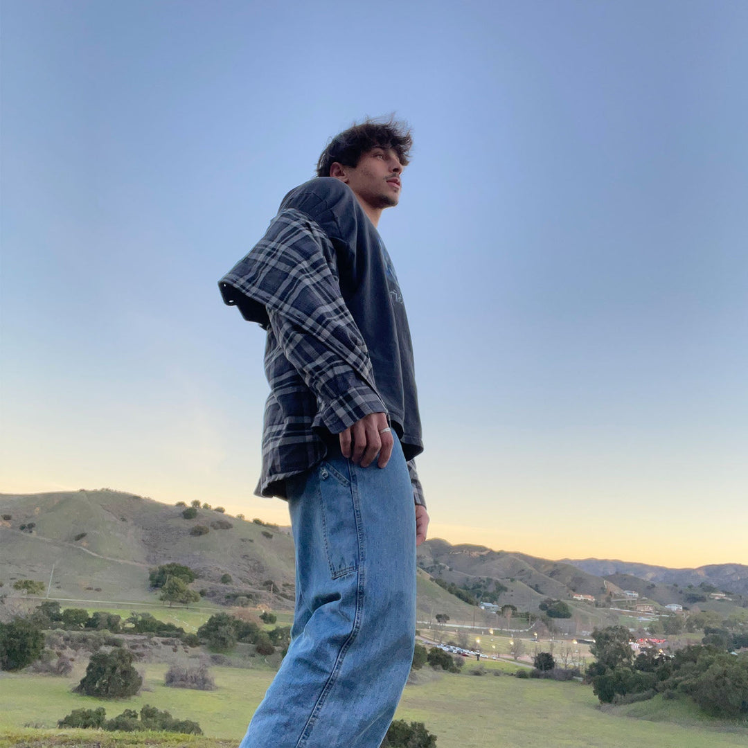 Stack of Men's Verona Plaid Flannel Shirts, showcasing various colorways and the soft cotton fabric.