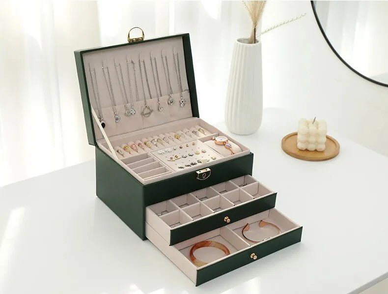 Open 3-tier jewelry box revealing compartments for rings, earrings, necklaces. Premium leather organizer.