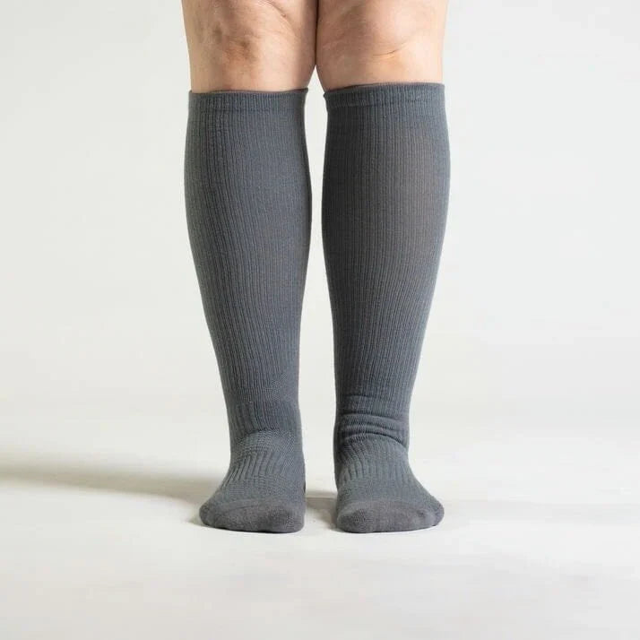 Pair of gray unisex gentle compression socks for daily wear and circulation support, flat lay.