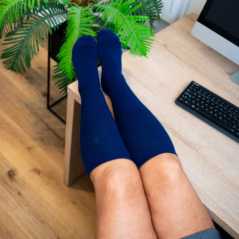 Folded navy blue unisex compression socks, emphasizing their soft texture and durability