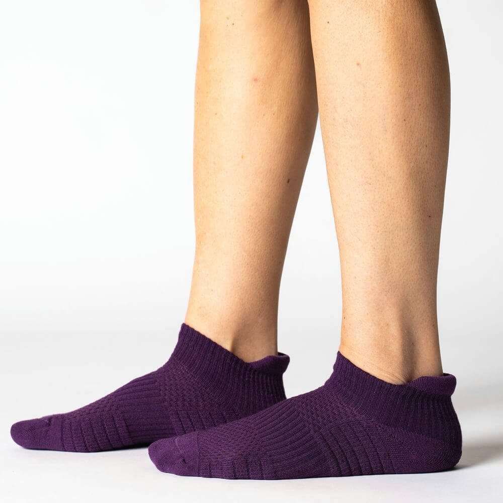 Unisex model wearing royal purple ankle support compression socks, showing ergonomic fit and style.